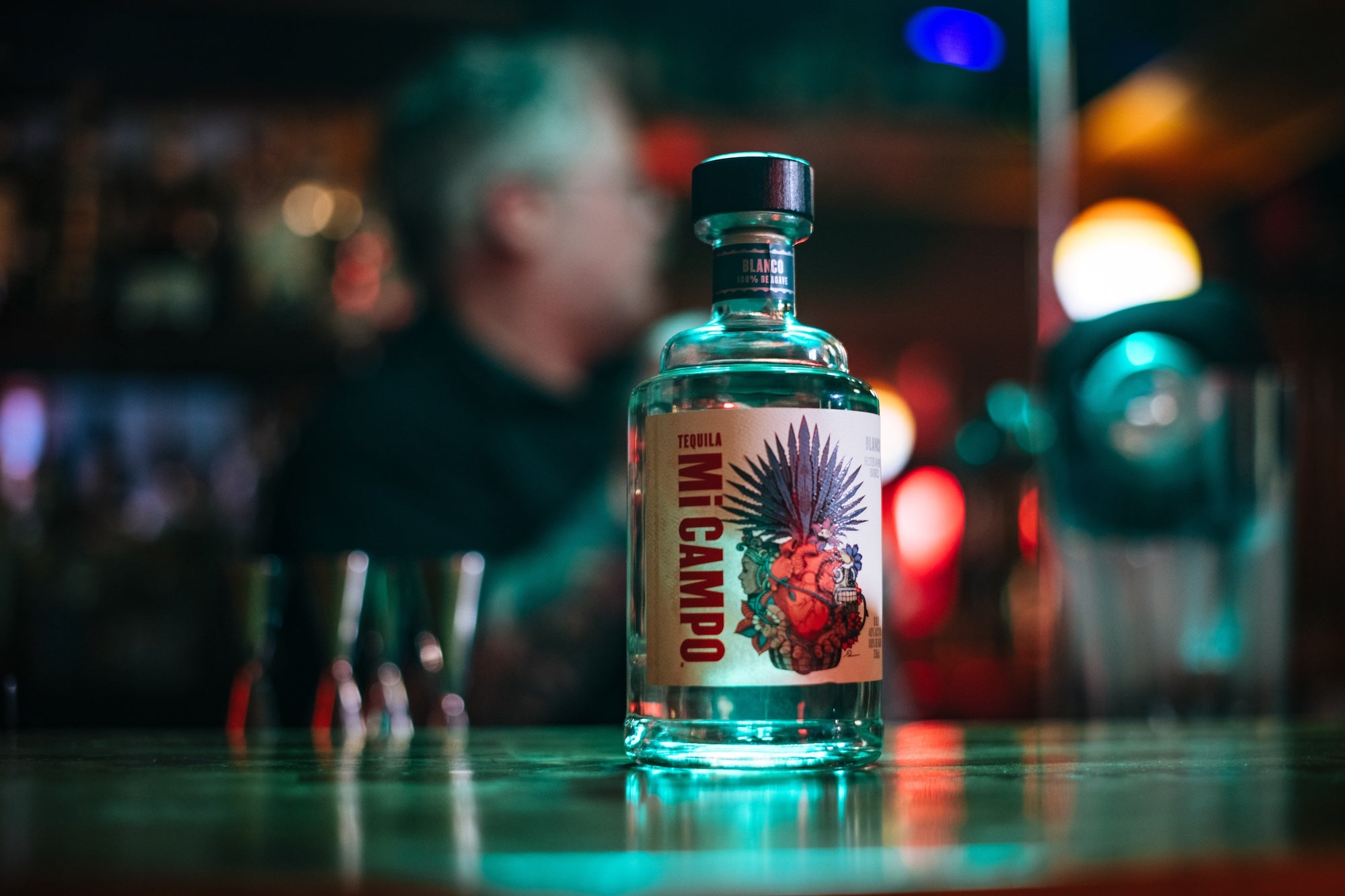 Bottle of Mi Campo on a bar with a blurred background