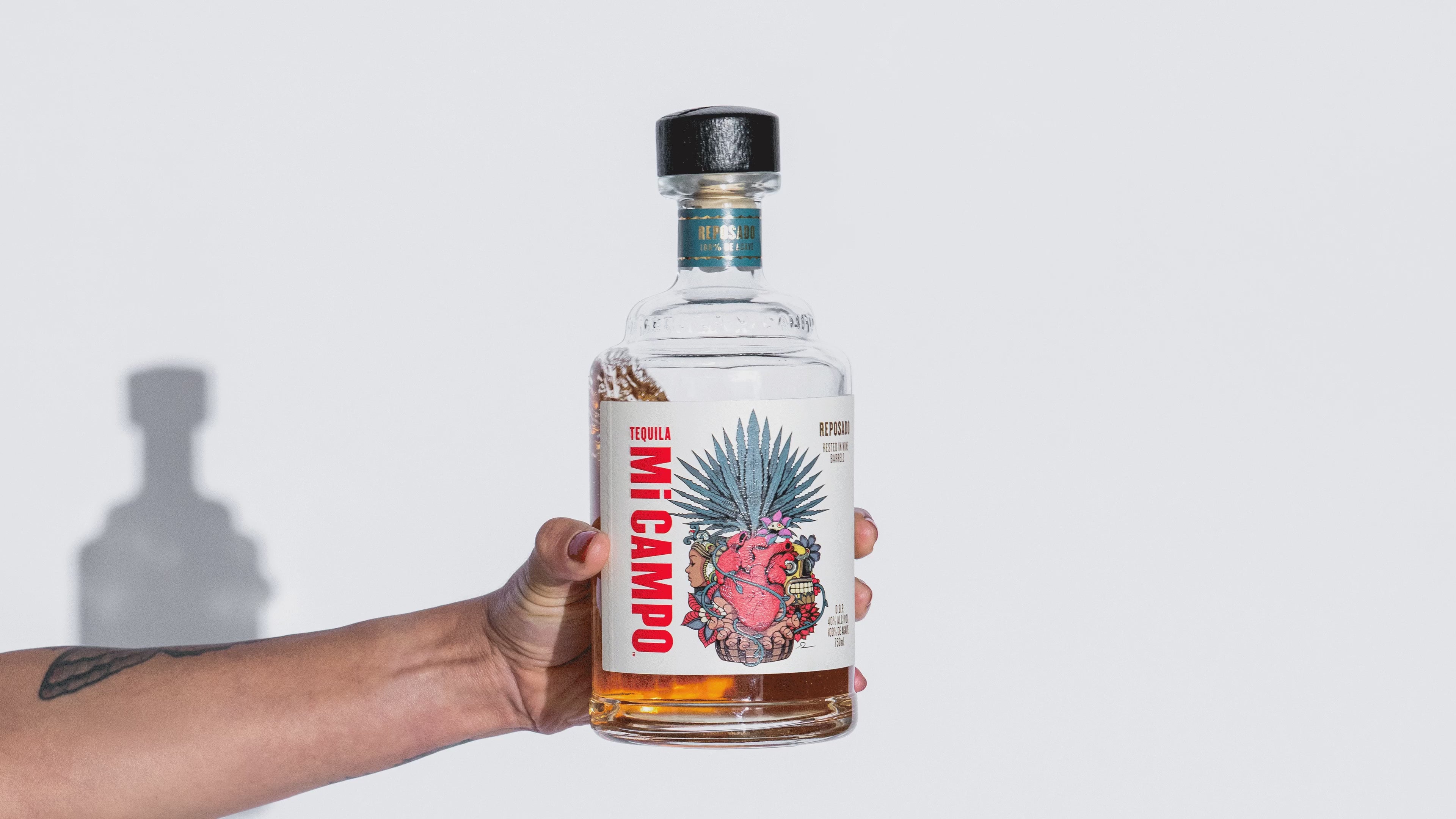 GIF of Mi Campo bottle with small branded stickers being applied around it
